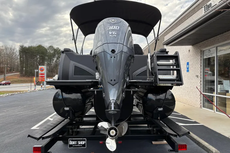 Slide: The Image of 2026 Veranda Vertex 235RC Premium pontoon boat with powerful outboard motor, parked at dealership. - 5