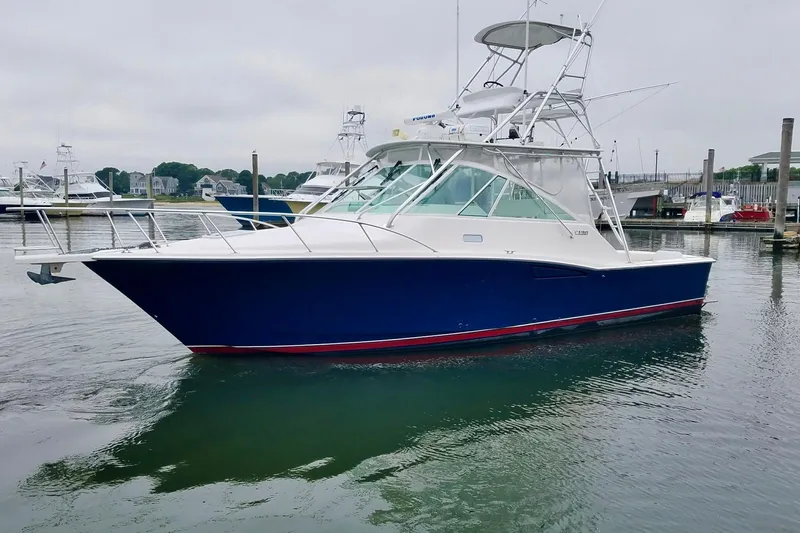 The Image of 2004 Cabo 35 Express Sportfish boat docked in a marina, side view. - 0