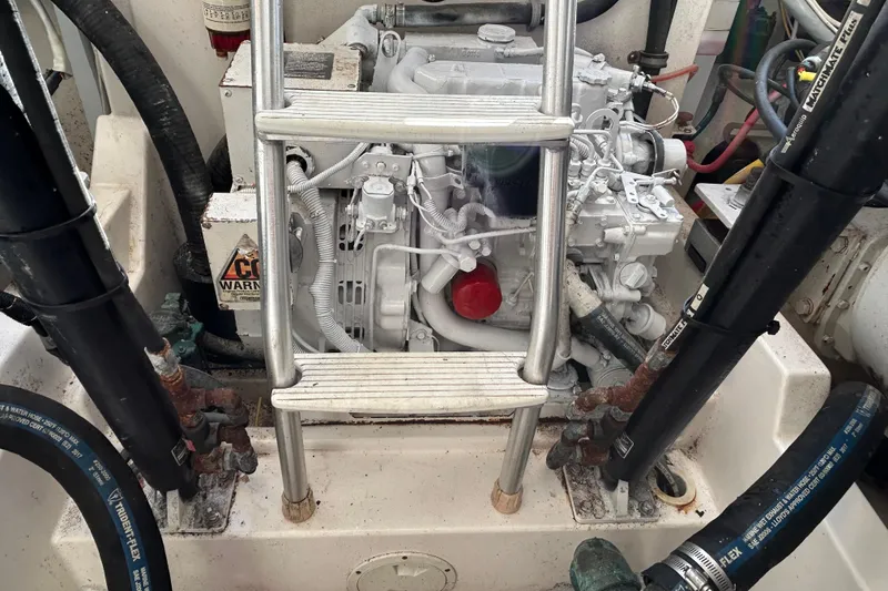 Slide: The Image of Engine compartment of a 2004 Cabo 35 Express Sportfish boat with visible ladder and hoses. - 13
