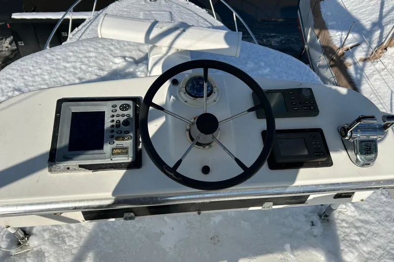 Slide: The Image of Helm of 2004 Cabo 35 Express Sportfish with navigation equipment, covered in snow. - 14