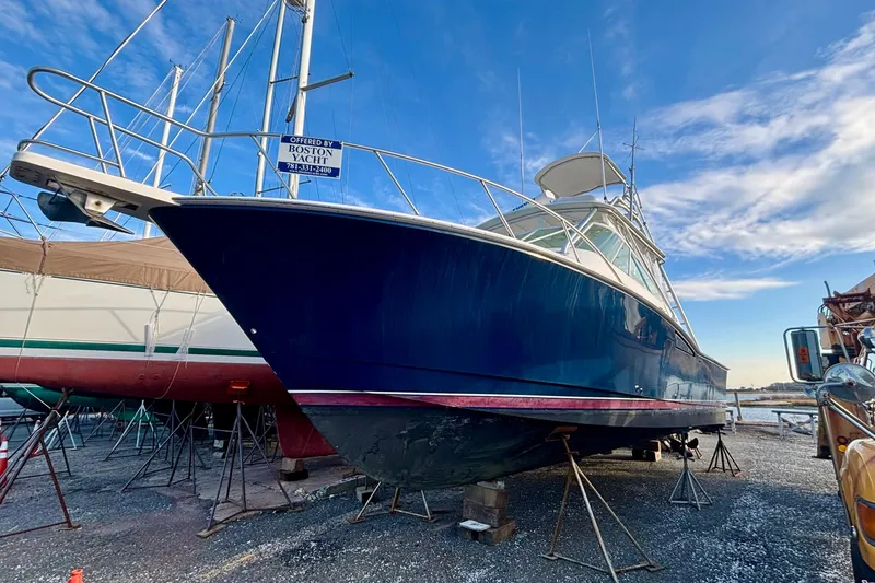 Slide: The Image of 2004 Cabo 35 Express Sportfish boat on stands, blue hull, clear sky background. - 15