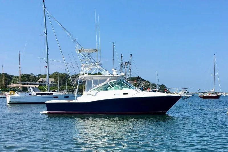 Slide: The Image of 2004 Cabo 35 Express Sportfish boat docked under clear blue sky. - 2
