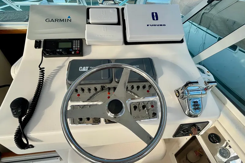 Slide: The Image of 2004 Cabo 35 Express Sportfish cabin interior with seating, bed, and wooden accents. - 6