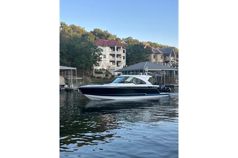 The Image of 2020 Formula 400 Super Sport Crossover boat docked near waterfront homes. - 1