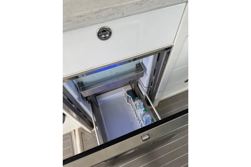Slide: The Image of 2020 Formula 400 Super Sport Crossover boat fridge with open drawer and water bottles. - 39