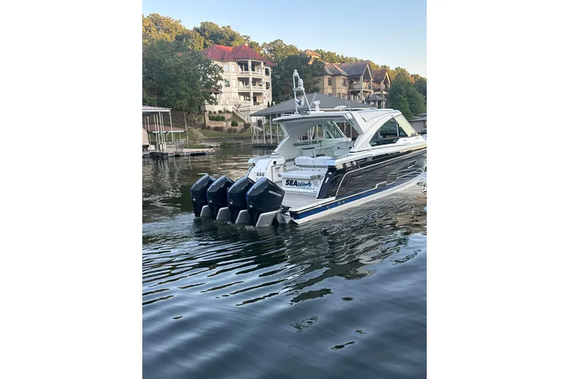 Slide: The Image of 2020 Formula 400 Super Sport Crossover boat on a serene lake near luxury homes. - 7