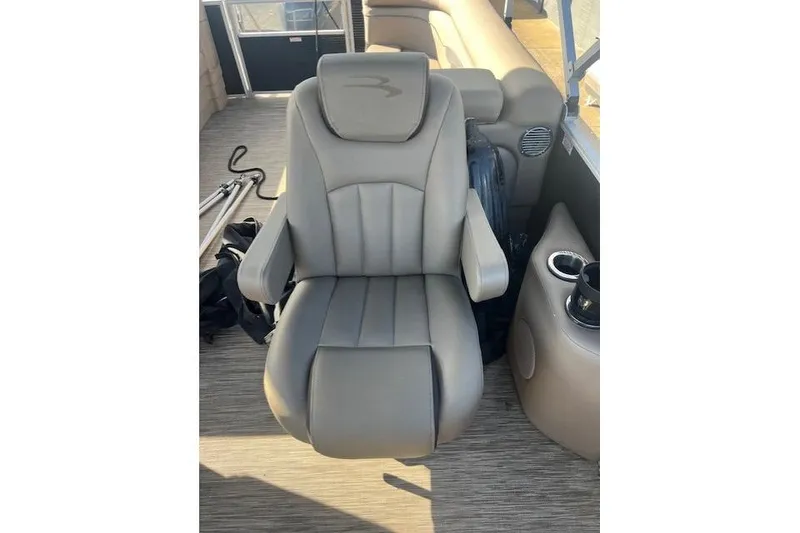 Slide: The Image of Captain's chair on 2021 Bennington 22 SSRX pontoon boat, featuring cup holders and armrests. - 7