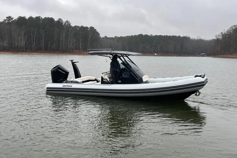 Slide: The Image of 2026 Brig Eagle 8 boat on a calm lake with forested shoreline. - 11