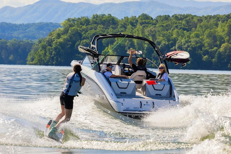 Slide: The Image of Manufacturer Provided Image: 2026 Yamaha Boats AR220 towing a wakeboarder on a scenic lake. - 6