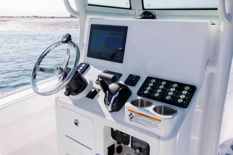 Slide: The Image of Caymas 26 HB 2026 helm with modern electronics and controls. - 14