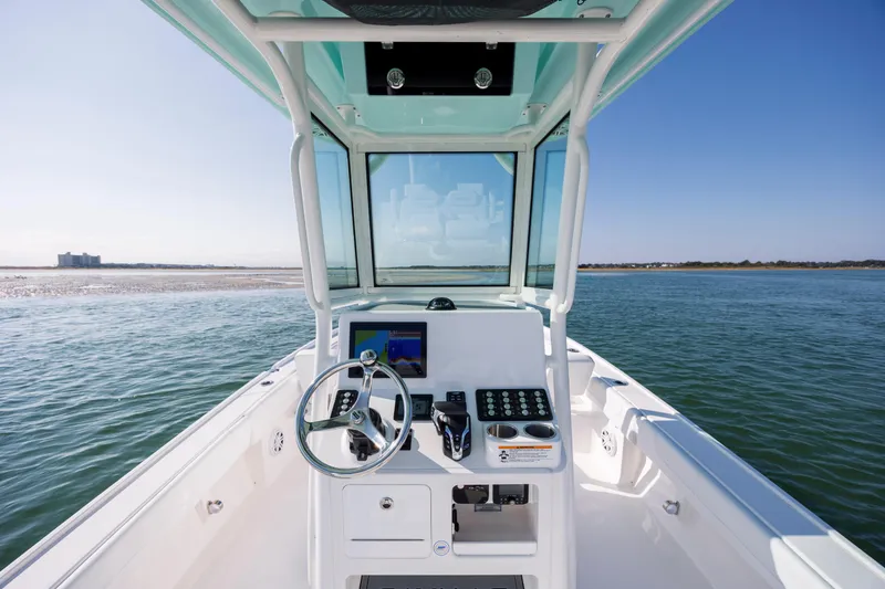 Slide: The Image of Helm of Caymas 26 HB boat, 2026 model, on open water. - 15