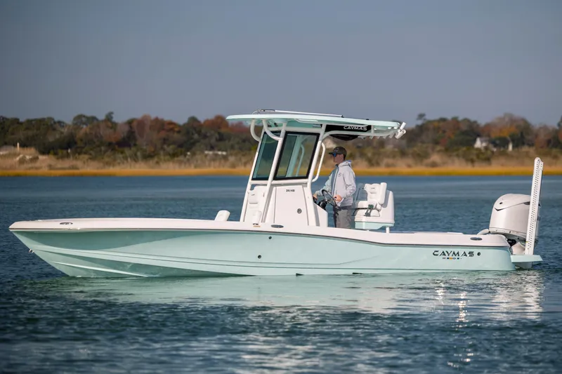Slide: The Image of Caymas 26 HB 2026 boat on calm water with driver. - 2