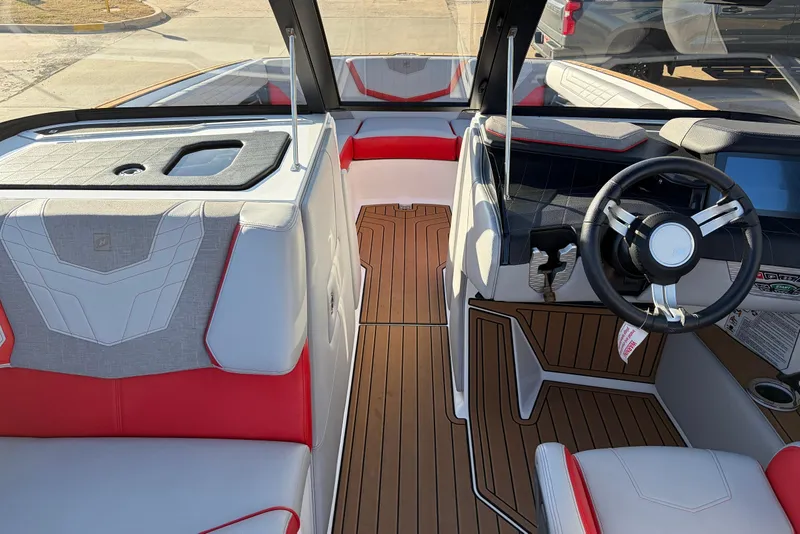 Slide: The Image of 2021 Nautique Super Air Nautique G23 interior with red and white seating, modern dashboard. - 21
