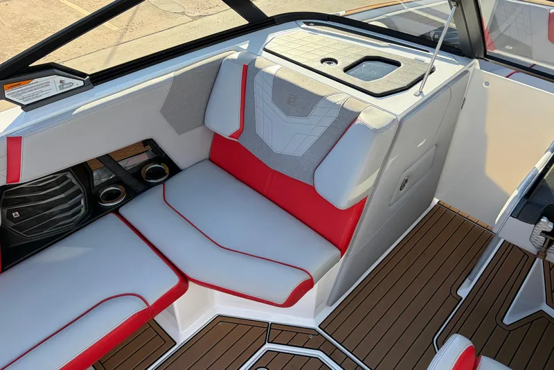 Slide: The Image of 2021 Nautique Super Air Nautique G23 interior with red and gray seating, cup holders, and teak flooring. - 27