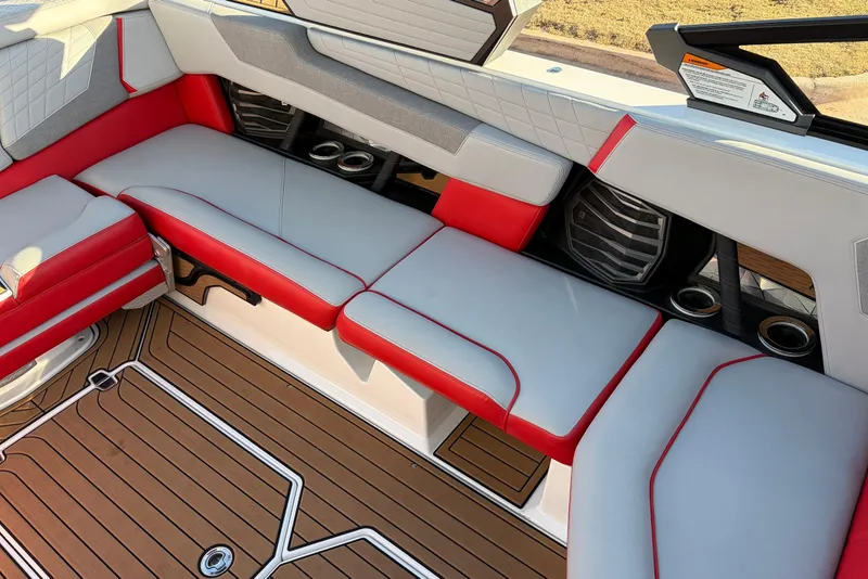 Slide: The Image of 2021 Nautique Super Air Nautique G23 interior with red and gray seating, teak flooring. - 31