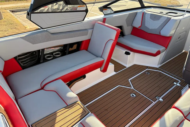 Slide: The Image of 2021 Nautique Super Air Nautique G23 interior with red and gray seating, teak flooring. - 33