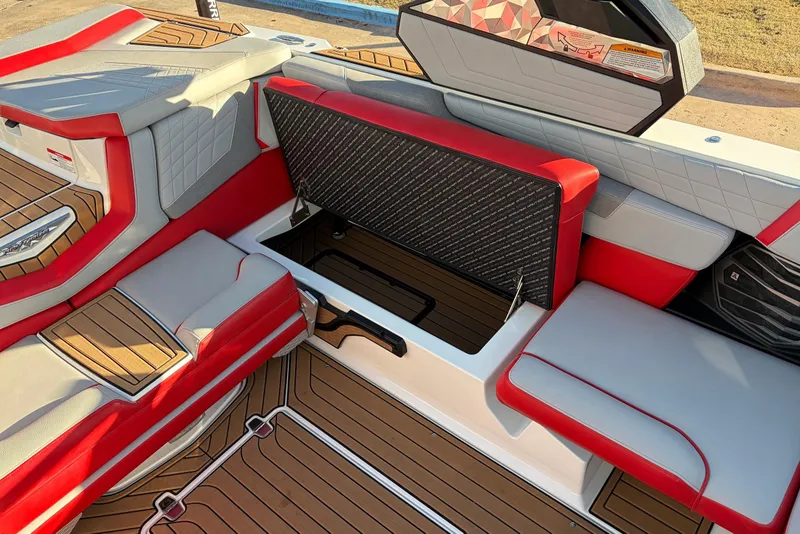 Slide: The Image of 2021 Nautique Super Air Nautique G23 interior with red and gray seating and storage compartment. - 34