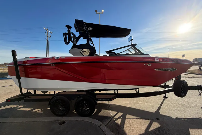 Slide: The Image of 2021 Nautique Super Air Nautique G23 boat on trailer, red and white design. - 4