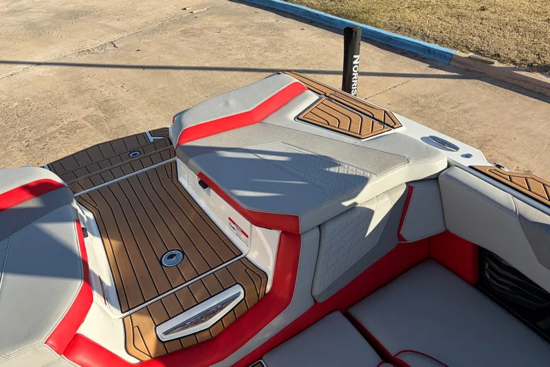 Slide: The Image of 2021 Nautique Super Air Nautique G23 boat interior with red and gray seating. - 53