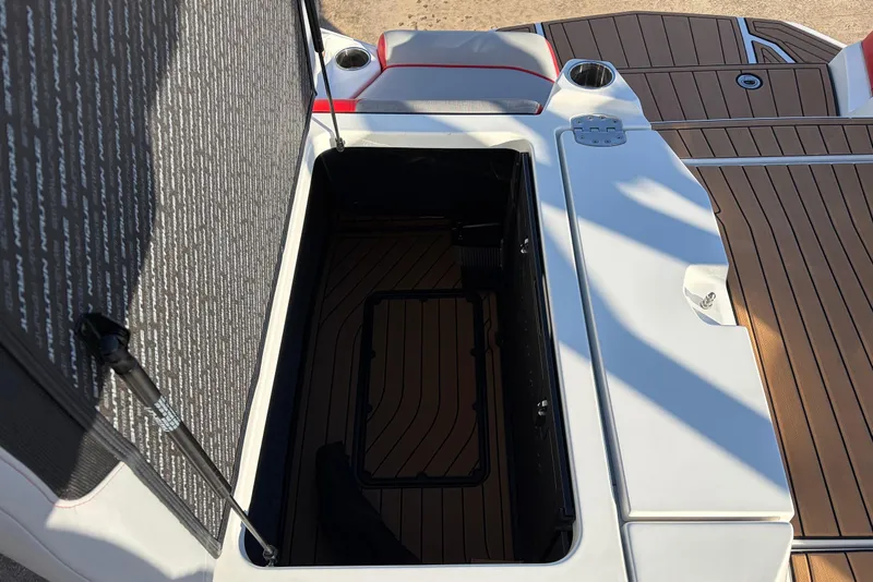 Slide: The Image of 2021 Nautique Super Air Nautique G23 storage compartment with open lid and teak flooring. - 55