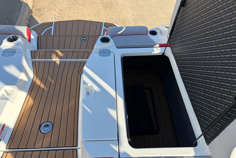 Slide: The Image of 2021 Nautique Super Air Nautique G23 boat with open storage compartment and teak deck. - 57