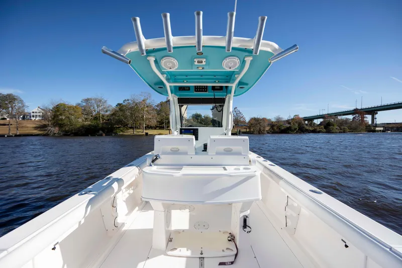 Slide: The Image of 2015 Everglades 255 Center Console boat on a river, clear sky, bridge in background. - 13