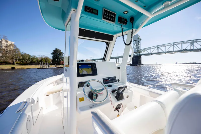 Slide: The Image of 2015 Everglades 255 Center Console boat on water near a bridge, sunny day. - 16