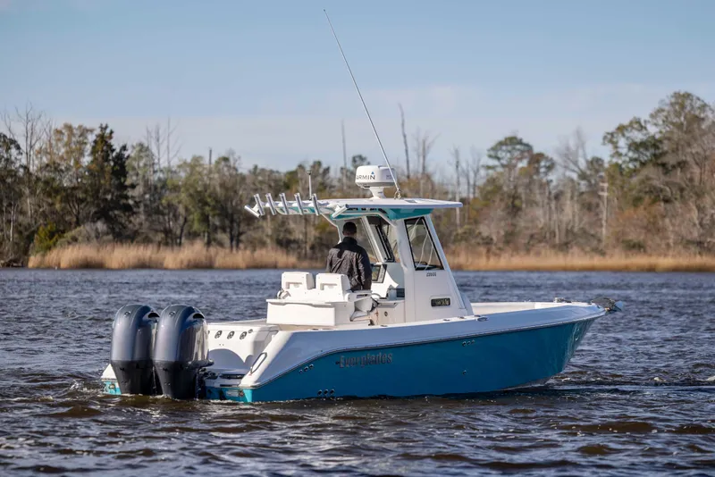 Slide: The Image of 2015 Everglades 255 Center Console boat cruising on a calm river. - 2