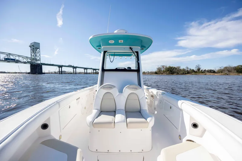 Slide: The Image of 2015 Everglades 255 Center Console boat on water near a bridge under blue sky. - 24