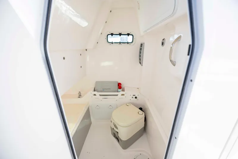 Slide: The Image of Interior of 2015 Everglades 255 Center Console boat, featuring compact cabin amenities. - 25
