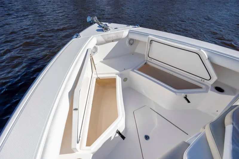Slide: The Image of 2015 Everglades 255 Center Console boat with open storage compartments on calm water. - 29