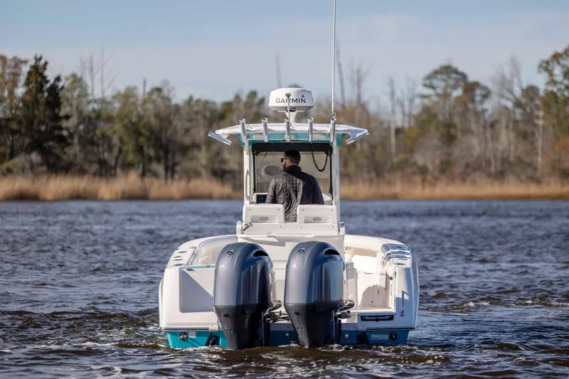 Slide: The Image of 2015 Everglades 255 Center Console boat on water, rear view with dual engines. - 3