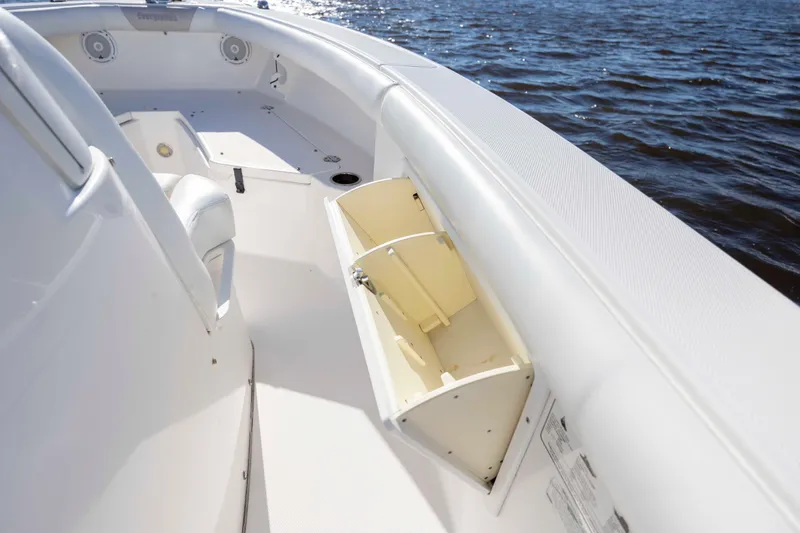 Slide: The Image of 2015 Everglades 255 Center Console boat interior with open storage compartment on calm water. - 31