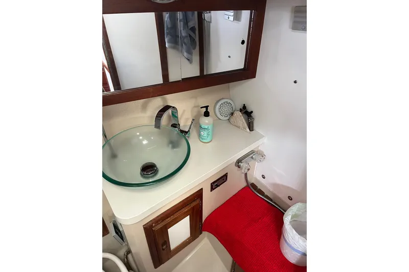Slide: The Image of Compact bathroom in 1986 Catalina 36 MK1 sailboat with glass sink and red mat. - 11