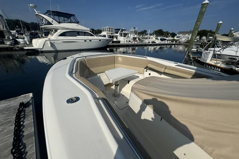 Slide: The Image of 2019 Sailfish 360 CC boat docked at marina with seating and table. - 11