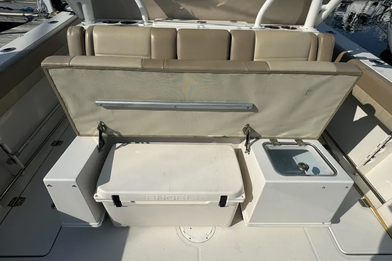 Slide: The Image of 2019 Sailfish 360 CC boat interior with seating, storage, and cooler. - 18