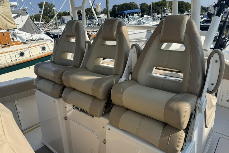 Slide: The Image of Three beige captain's chairs on a 2019 Sailfish 360 CC boat, docked at a marina. - 24