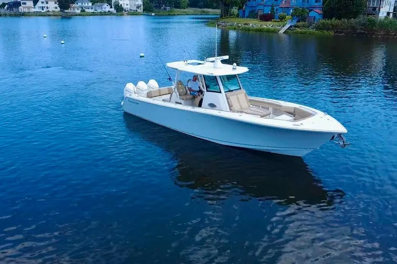 Slide: The Image of 2019 Sailfish 360 CC boat on calm water near residential shoreline. - 3