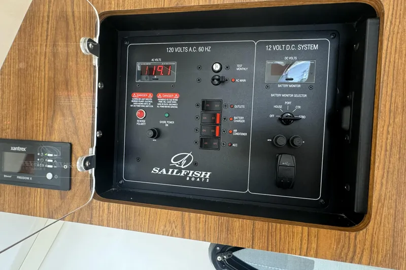 Slide: The Image of Control panel of a 2019 Sailfish 360 CC boat, featuring AC and DC systems. - 32