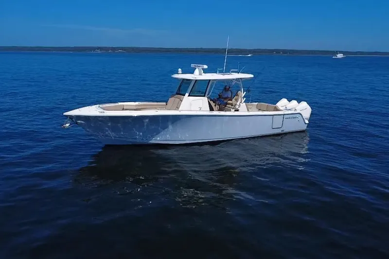 Slide: The Image of 2019 Sailfish 360 CC boat on calm blue water under clear sky. - 7