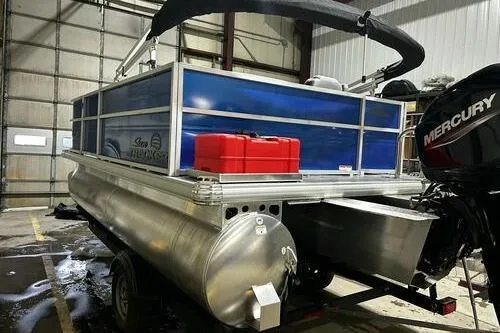 Slide: The Image of 2026 Sun Tracker Party Barge 16 DLX pontoon boat with Mercury engine in a garage. - 4