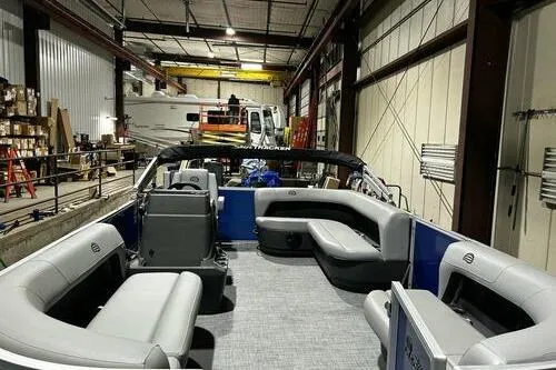 Slide: The Image of 2026 Sun Tracker Party Barge 16 DLX pontoon boat in a warehouse setting. - 5