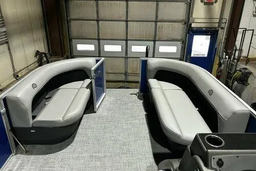 Slide: The Image of 2026 Sun Tracker Party Barge 16 DLX interior with gray seating in a garage setting. - 7