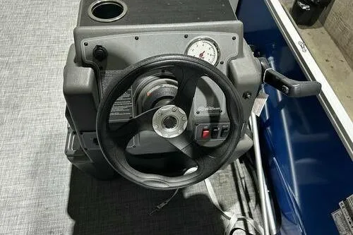 Slide: The Image of 2026 Sun Tracker Party Barge 16 DLX steering console with gauge and controls. - 9