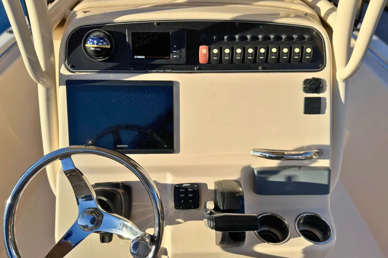 Slide: The Image of 2018 Grady-White Fisherman 216 boat dashboard with steering wheel and control panel. - 13