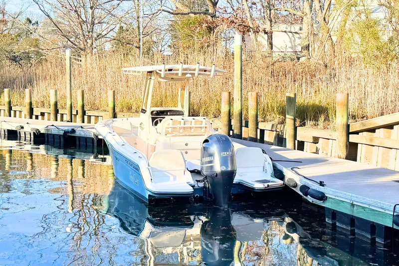 Slide: The Image of 2018 Grady-White Fisherman 216 boat docked by a wooden pier in a serene setting. - 2