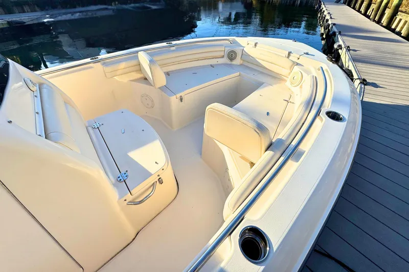 Slide: The Image of 2018 Grady-White Fisherman 216 boat interior with seating and storage, docked by calm water. - 6