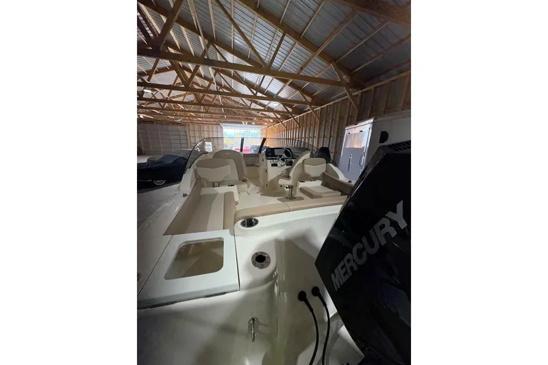 Slide: The Image of 2024 Scout 215 Dorado boat interior with Mercury engine in a wooden storage shed. - 3