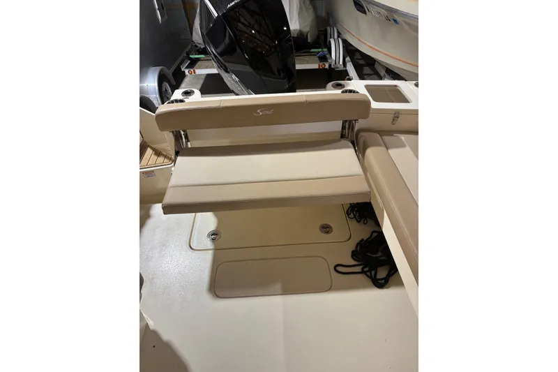 Slide: The Image of 2024 Scout 215 Dorado boat interior with beige seating and storage area. - 5