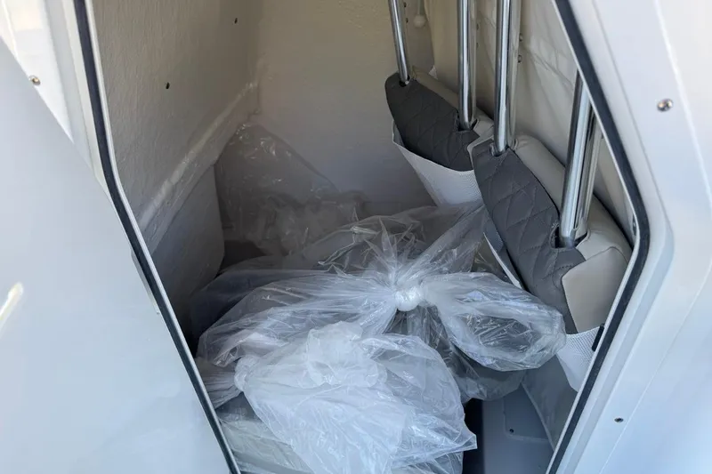 Slide: The Image of Interior storage compartment of 2026 Key West 219 FS boat with plastic-wrapped items. - 21
